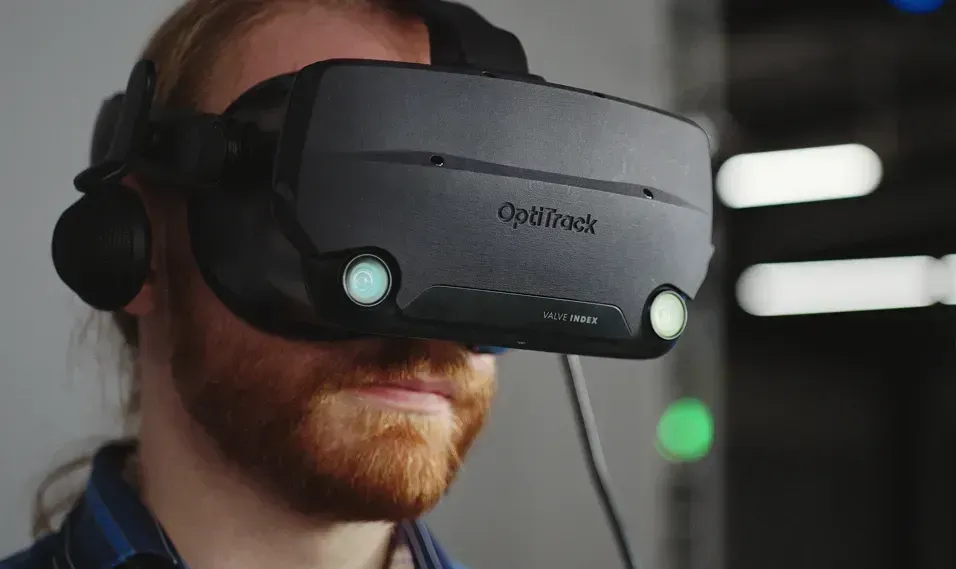 Person wearing a virtual reality headset with a motion tracking clip. 