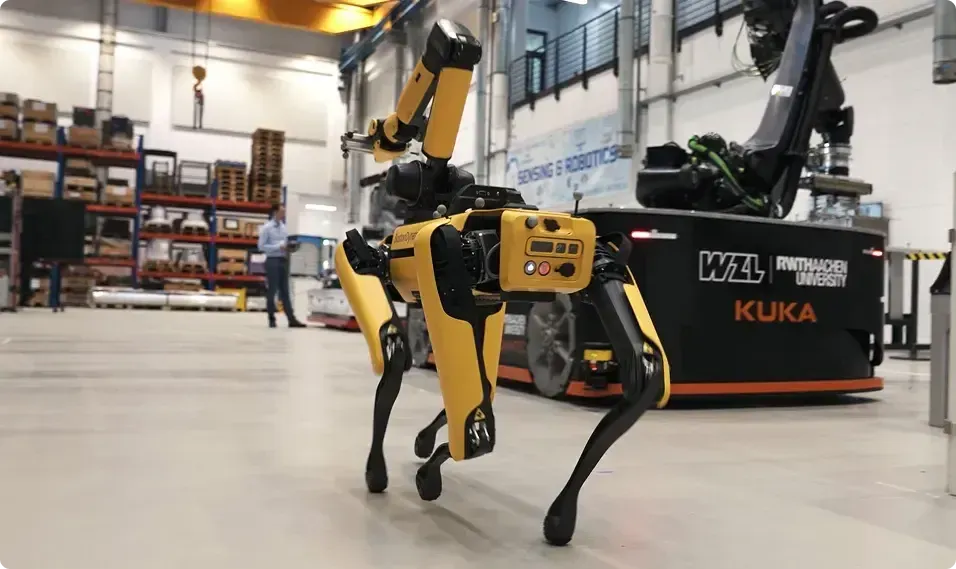 Robotic drone dog walking through a warehouse.